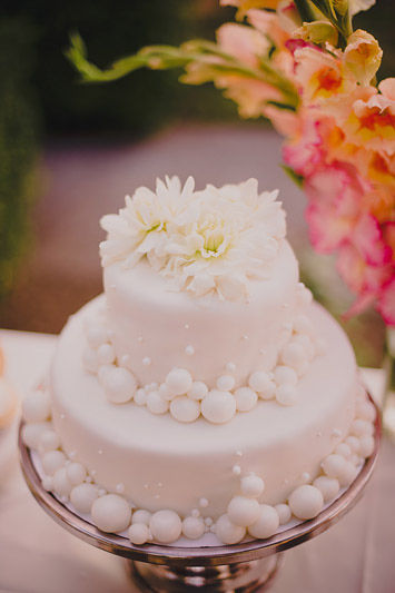 Lovely and unique two-tiered wedding cake with white sugar ball details - Photo by Ryan Flynn Photography